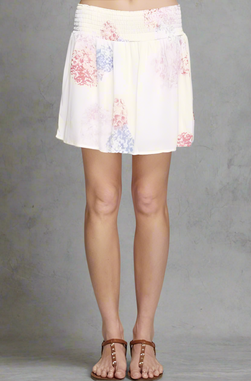 White rayon gauze skirt with smocked waistband and soft watercolor floral print in pink, purple, and blue.