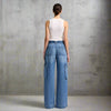 Back view of high-waisted wide-leg cargo jeans with patch pockets and side cargo flaps, styled with a white tank.