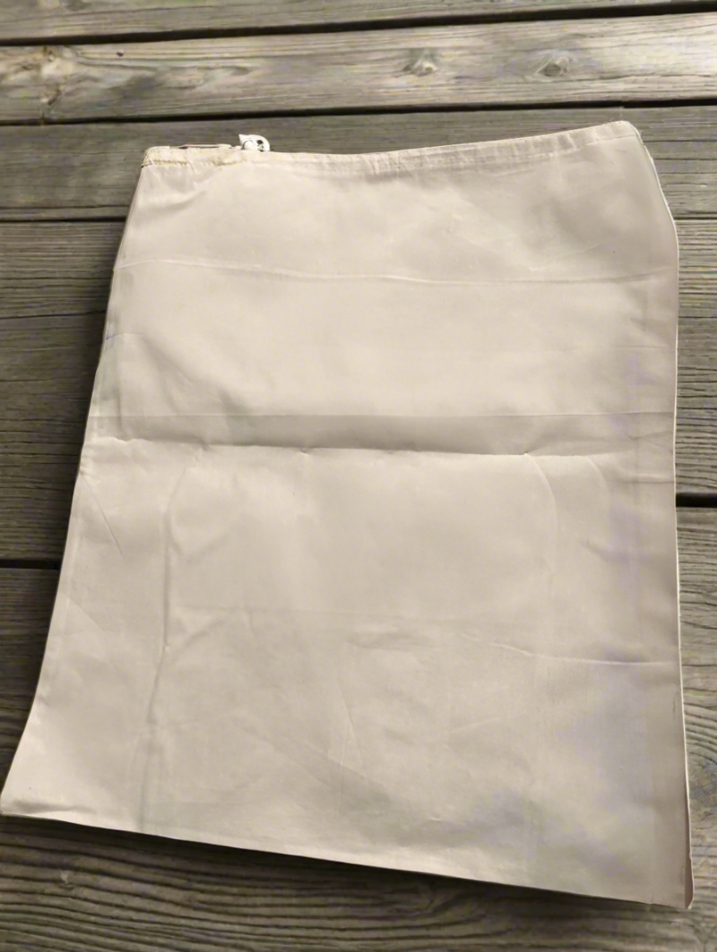 A cotton muslin drawstring dust bag on a wooden table