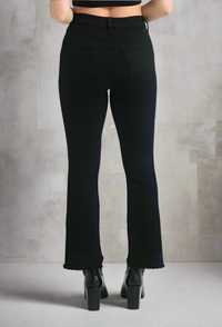 Back view of black demi bootcut jeans with frayed hems, styled with black platform ankle boots and a crop top