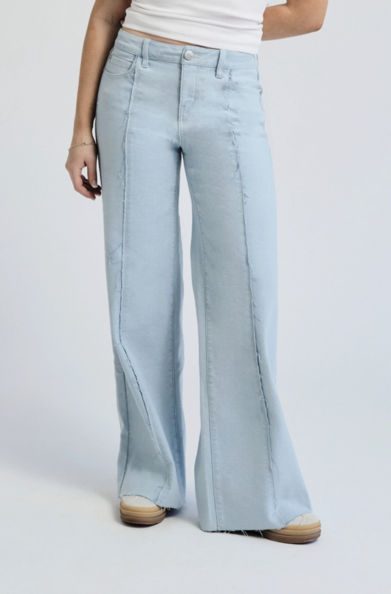 Light-wash wide-leg denim jeans featuring frayed seams, a high-rise fit, and raw hem details.