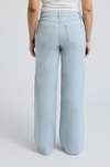 Light-wash wide-leg denim jeans featuring frayed seams, a high-rise fit, and raw hem details.

