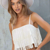 White sparkle fringe cami top with spaghetti straps and cropped fit styled with denim shorts.

