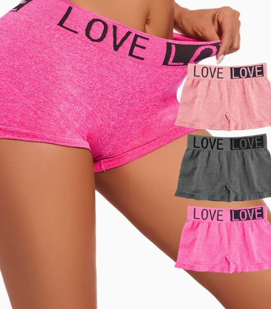 Close-up of a model wearing pink heathered seamless boxer briefs with a LOVE waistband, featuring a stretchy, high-waisted fit. Additional colors include light pink, dark gray, and bright pink.

