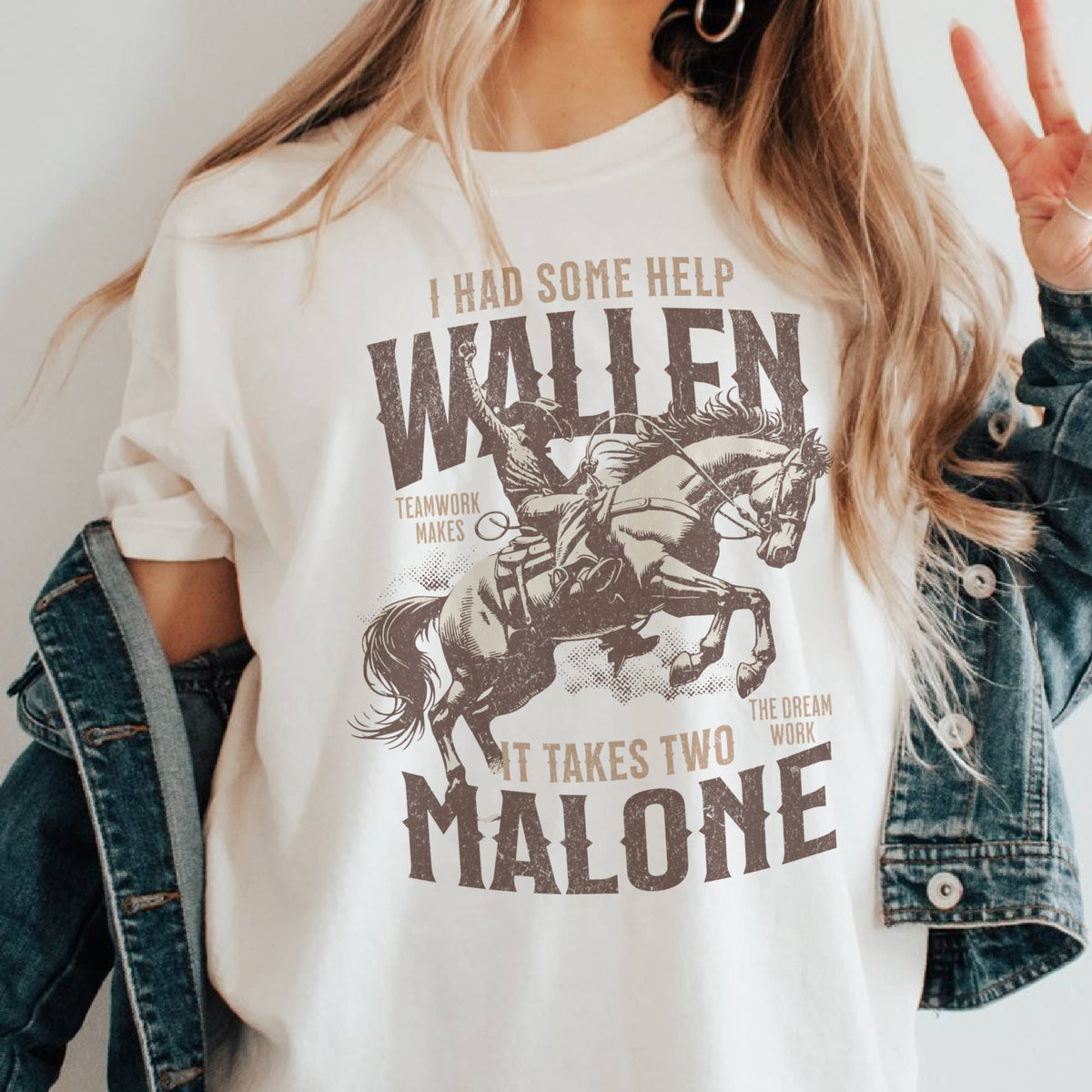 A vintage-inspired graphic t-shirt featuring a cowboy on horseback with bold Western typography that reads "I Had Some Help Wallen Malone."