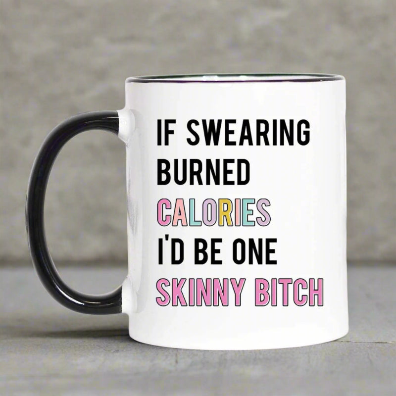 White ceramic mug with black handle and rim, featuring the quote “If Swearing Burned Calories I’d Be One Skinny Bitch” in bold and pastel lettering.

