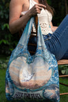 Turquoise linen tote bag with vintage dove and “Keep the Peace” design, worn over the shoulder