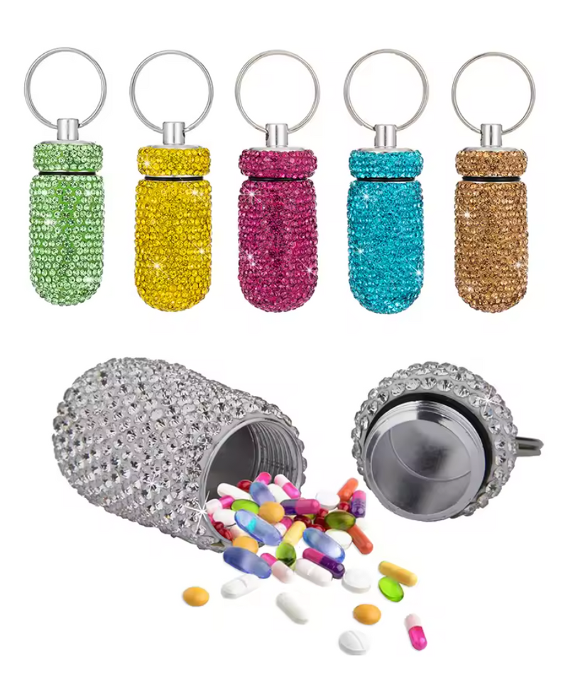 Assorted rhinestone pill holder keychains in green, yellow, pink, blue, and gold with a silver keyring.