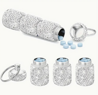 A triple-compartment rhinestone pill holder with a secure keychain and strap, designed for stylish and convenient pill storage on the go.
