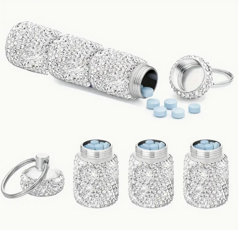 A triple-compartment rhinestone pill holder with a secure keychain and strap, designed for stylish and convenient pill storage on the go.