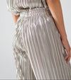 Close-up of metallic silver pleated pants showing elastic waistband and textured shimmer fabric








