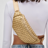 A golden woven neoprene belt bag worn across the chest, featuring an adjustable strap and sleek, modern design for hands-free convenience.