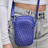 Close-up of a stylish woven neoprene crossbody bag in a vibrant periwinkle shade, featuring a compact design with multiple zippered compartments and an adjustable strap.