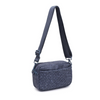 A sleek dark denim woven neoprene crossbody bag with an adjustable strap, styled for a casual yet chic look.

